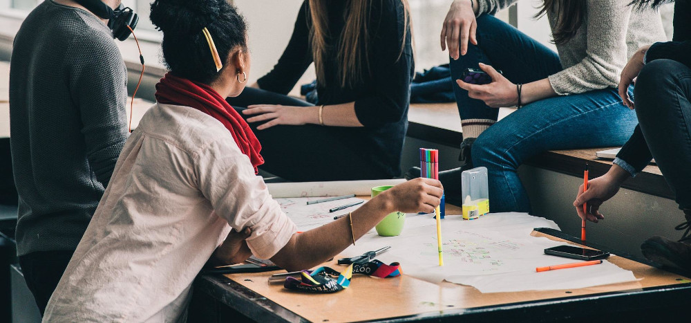 Photo : Plusieurs étudiants discutent en classe.