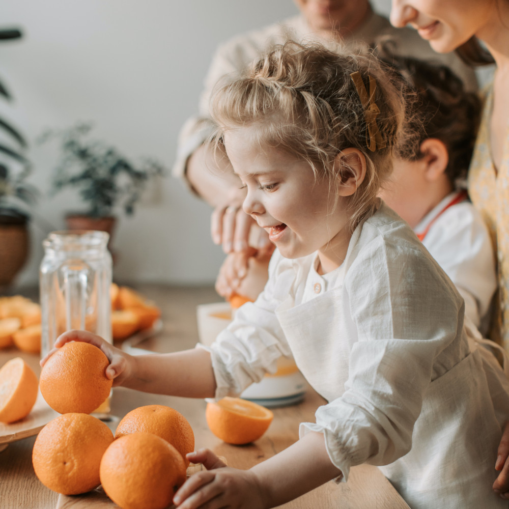 Une petite fille joue avec des oranges.