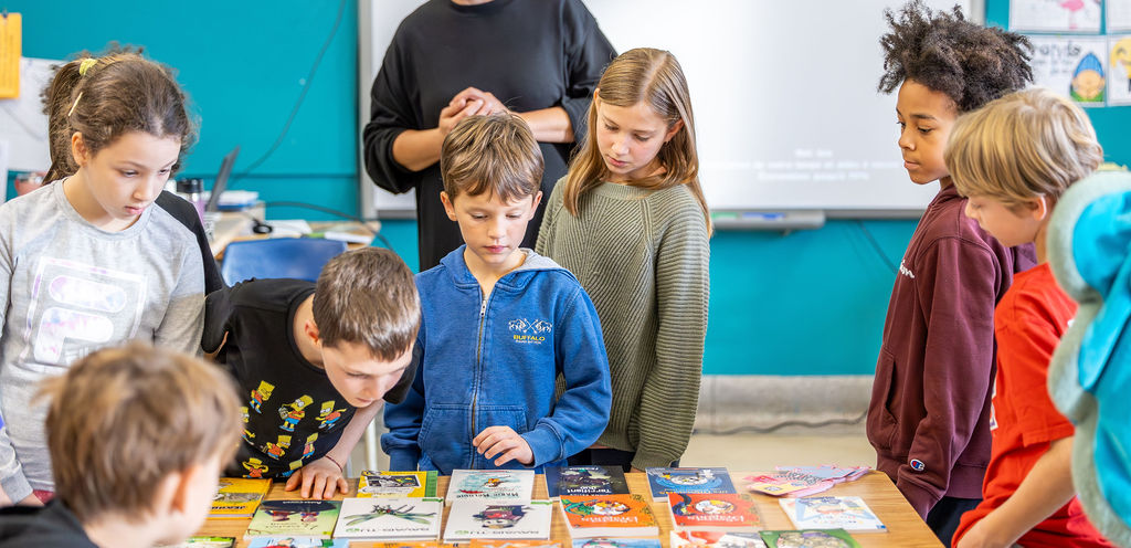 Deux jeunes garçons tiennent chacun un livre de Geronimo Stilton: "Un Weekend d'enfer pour Geronimo" et "Le Train le plus raide du Far West"