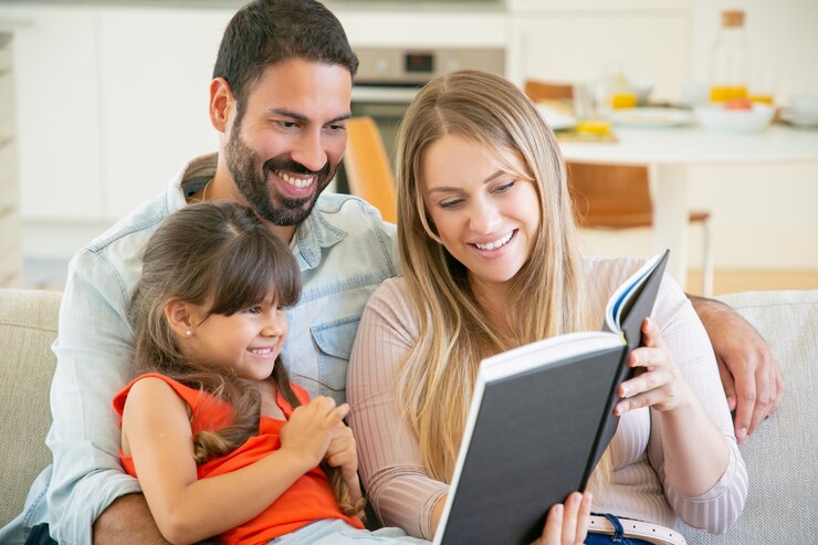 joyful-parents-couple-little-black-haired-girl-sitting-couch-living-room-reading-book-together-laughing_74855-8131 Illustration d'un mère qui lit à ses enfants.